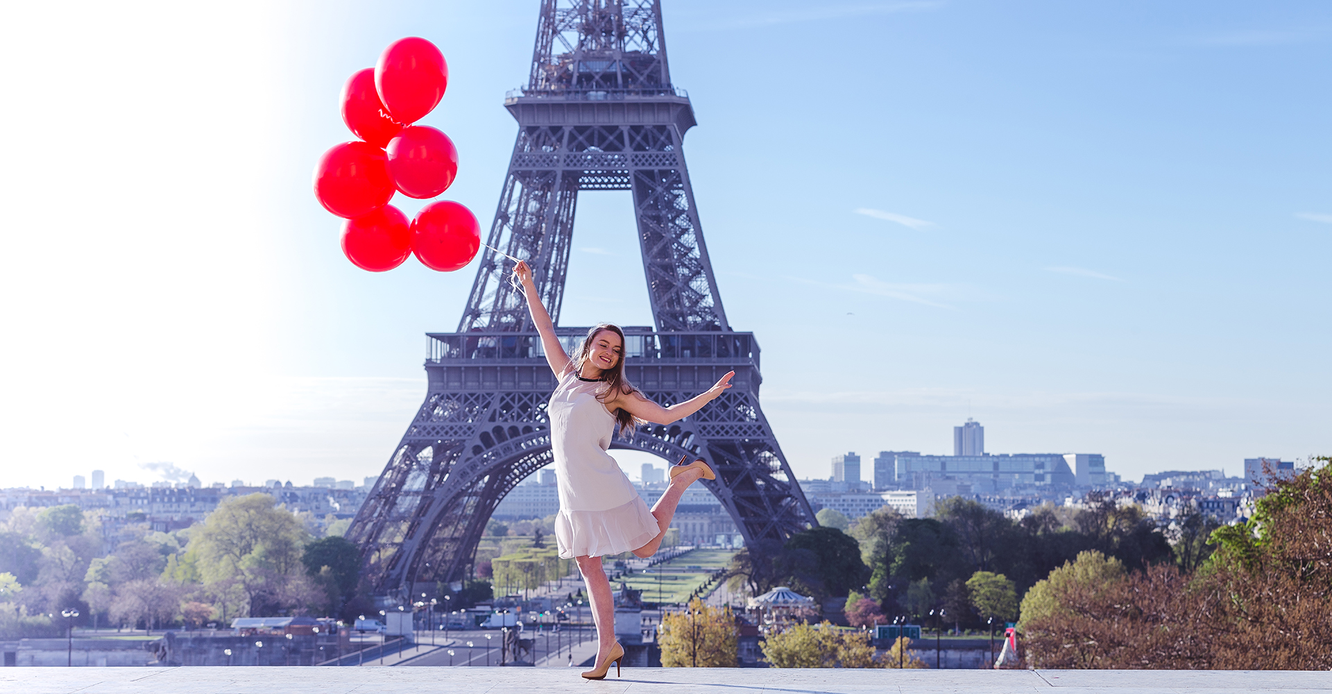 Chica bonita sonriendo mientras salta alegremente cerca del Eiffel Francia